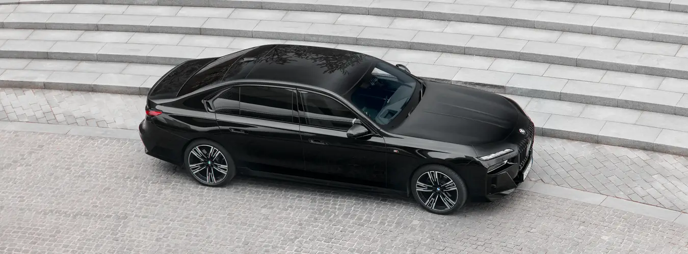 Black BMW luxury saloon parked outside a building