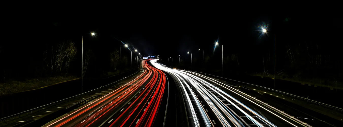 Motorway at night with car light trails on a long-distance route