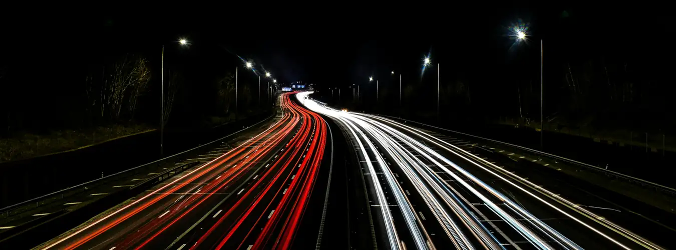 Motorway at night with car light trails on a long-distance route