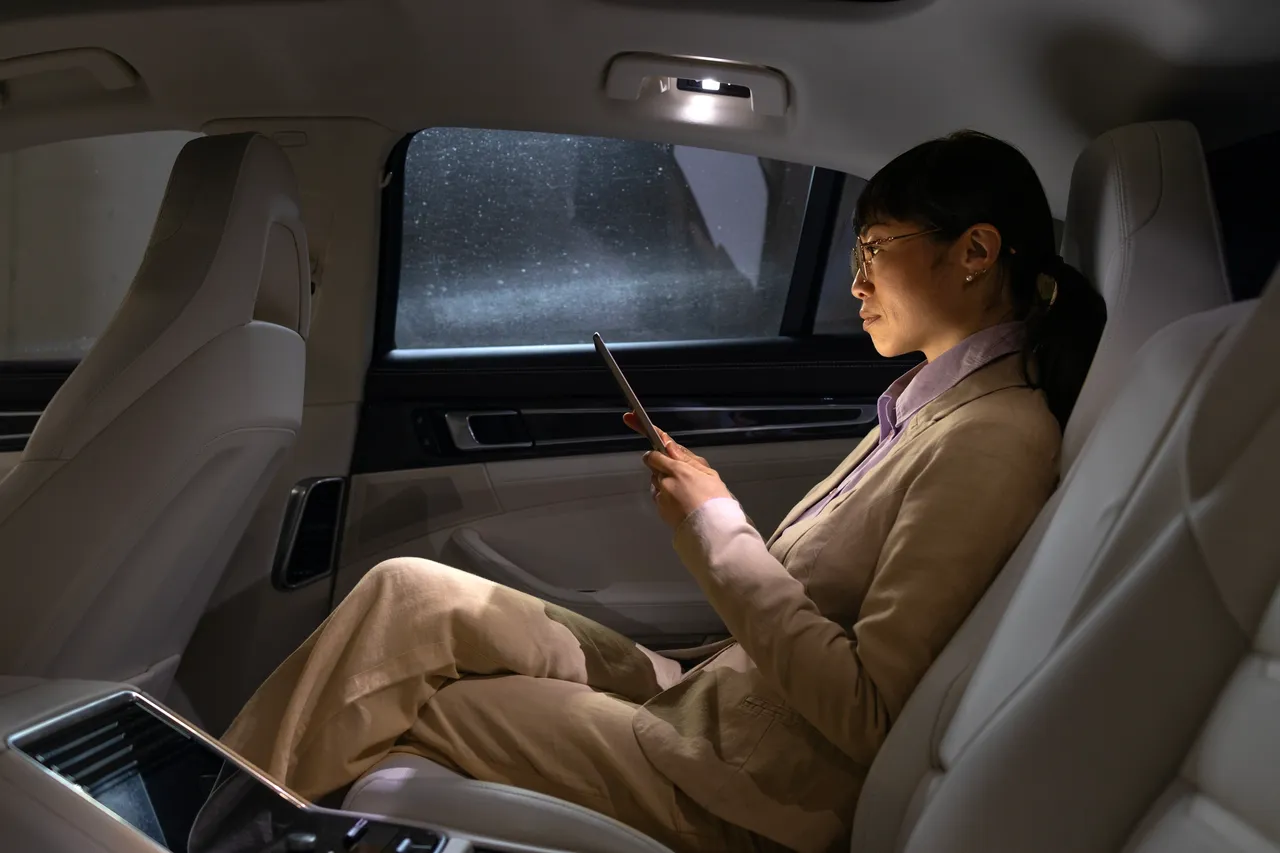 Businesswoman working on a tablet in the back seat of a chauffeured car