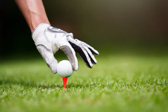 Golfer placing a ball on a tee on the course