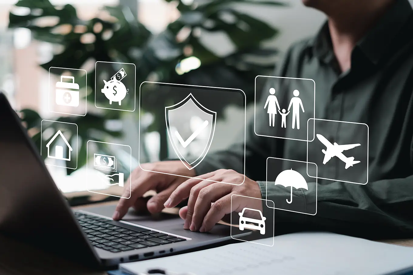 Travel agent at a laptop with travel insurance and protection icons
