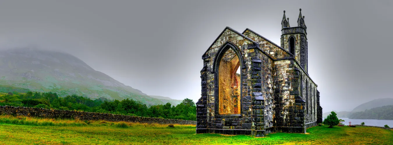 Old stone church ruin in the Irish countryside with misty hills