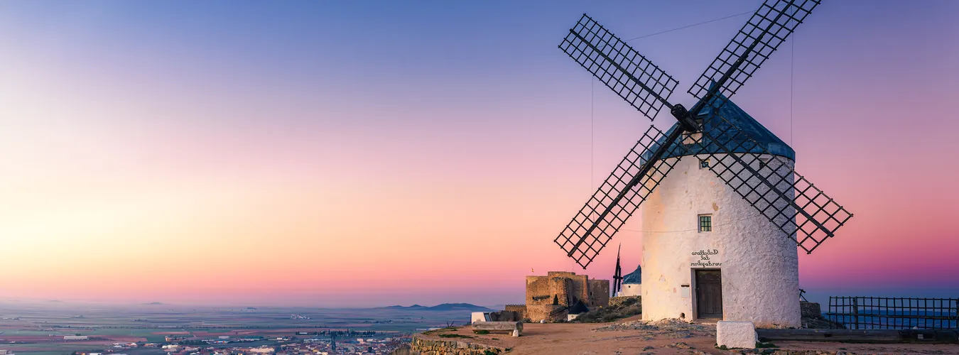 Historic stone windmill on a hilltop at sunset