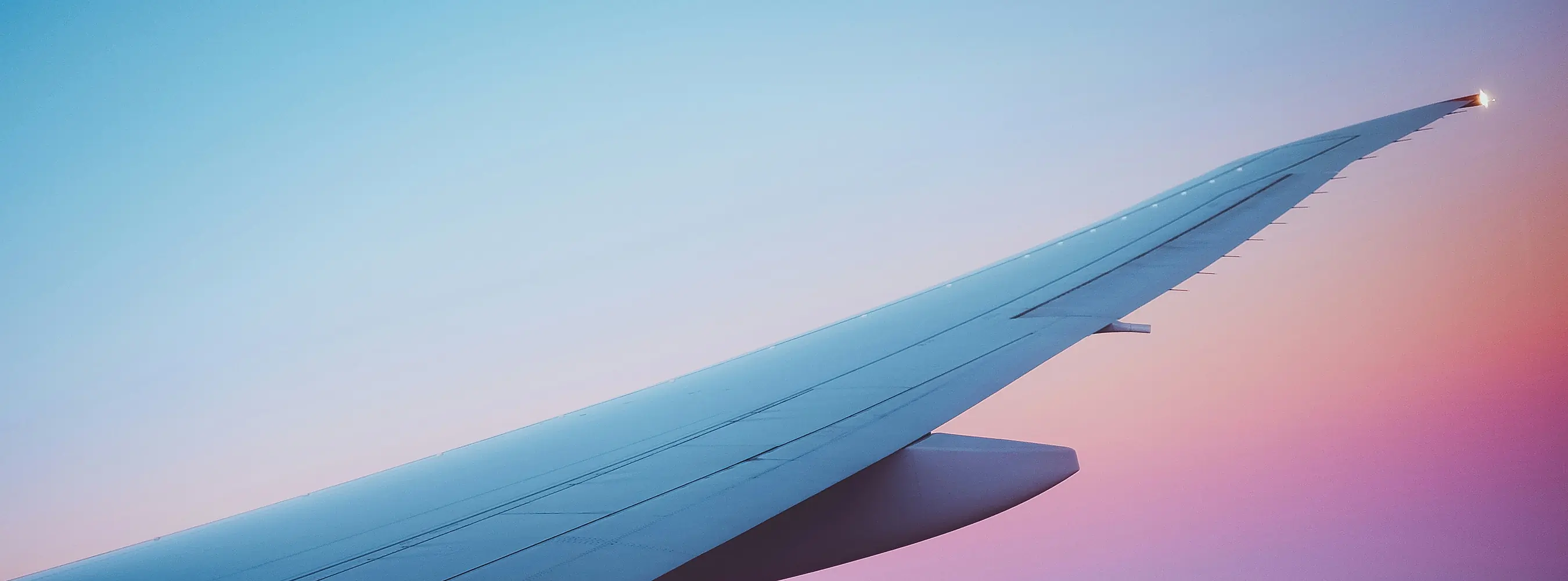 Aeroplane wing at sunrise seen from a passenger window seat